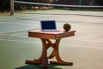 Tennis court with table with laptop and ball, generated by Adobe Firefly