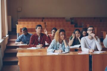 Students talking and laughing in a lecture hall by Vitaly Gariev via Unsplash