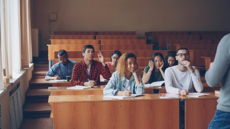 Students talking and laughing in a lecture hall by Vitaly Gariev via Unsplash